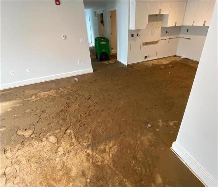 muddy debris on floor of house under remodel, white wall cabinets