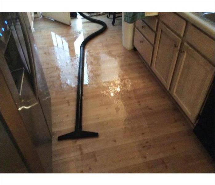 wand and hose on the floor of wet kitchen
